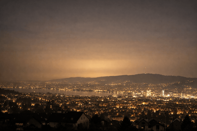 Nächtliche Stadtansicht mit starker Lichtverschmutzung und aufgehelltem Himmel über urbanem Gebiet.